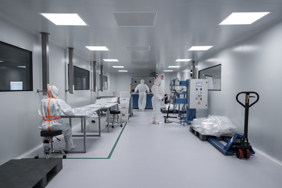 Reinraum mit Fertigungslinie und Beschäftigten in Schutzanzügen