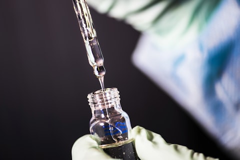 Pipette über einem Glasfläschchen im Labor